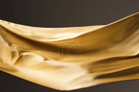 Foto de Primer plano de tela de seda brillante dorado con espacio para copiar sobre fondo negro. Textura, tela, tela, color y material. - Imagen libre de derechos
