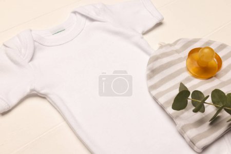 Photo for Flat lay of white baby grow, hat and dummy with copy space on white background. Baby fashion, clothes, colour and fabric concept. - Royalty Free Image