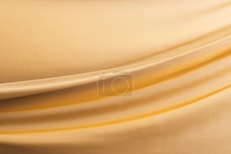 Foto de Primer plano de tela de seda brillante dorado con fondo de espacio de copia. Textura, tela, tela, color y material. - Imagen libre de derechos