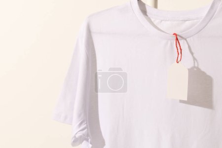 Foto de Camiseta blanca con etiqueta con espacio de copia sobre fondo blanco. Moda, ropa, color y concepto de tela. - Imagen libre de derechos