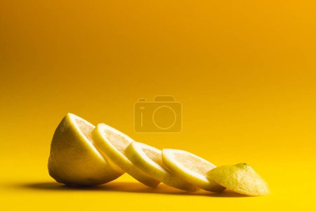 Téléchargez les photos : Gros plan de citron tranché avec espace de copie sur fond jaune. Fruits, nourriture, fraîcheur et concept de couleur. - en image libre de droit