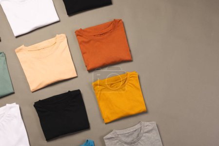 Foto de Camisetas multicolores con espacio para copiar sobre fondo gris. Moda, ropa, color y concepto de tela. - Imagen libre de derechos