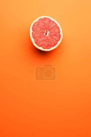 Photo for Close up of half of red grapefruit and copy space on orange background. Fruit, food, freshness and colour concept. - Royalty Free Image