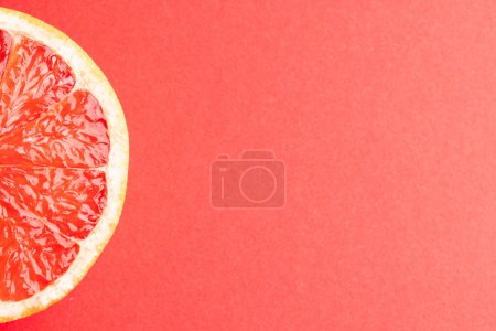Photo for Close up of slice of red grapefruit and copy space on red background. Fruit, food, freshness and colour concept. - Royalty Free Image