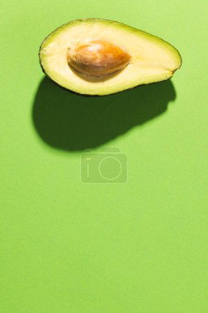 Photo for Close up of halved avocado and copy space on green background. Vegetable, food, freshness and colour concept. - Royalty Free Image
