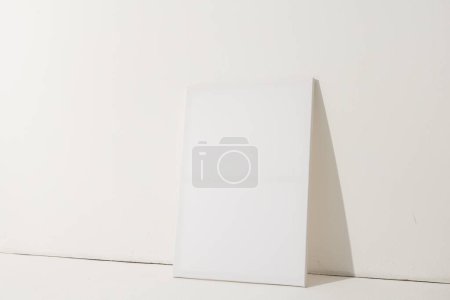 Foto de Lienzo blanco y espacio de copia apoyado sobre fondo blanco de la pared. Señalización, espacio de escritura y concepto publicitario. - Imagen libre de derechos