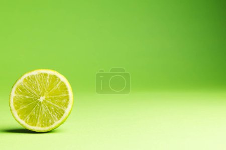 Téléchargez les photos : Gros plan de la chaux coupée en deux et copier l'espace sur fond vert. Fruits, fruits exotiques, nourriture, concept de fraîcheur et de couleur. - en image libre de droit