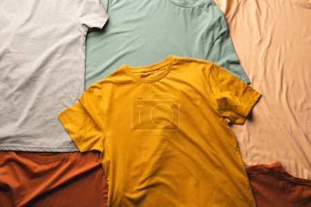 Foto de Primer plano de la disposición plana de camisetas multicolores y copia de fondo espacio. Moda, ropa, color y concepto de tela. - Imagen libre de derechos