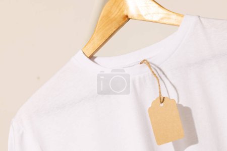 Photo for White t shirt with tag on hanger with copy space on white background. Fashion, clothes, colour and fabric concept. - Royalty Free Image