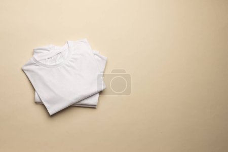 Photo for Close up of folded white t shirts and copy space on yellow background. Fashion, clothes, colour and fabric concept. - Royalty Free Image