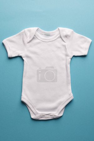 Foto de Colocación plana de bebé blanco crecer con espacio de copia sobre fondo azul. Moda de bebé, ropa, color y concepto de tela. - Imagen libre de derechos
