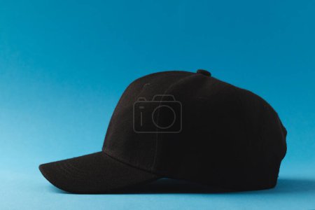 Foto de Gorra de béisbol negra y espacio de copia sobre fondo azul. Moda, ropa, color y concepto de tela. - Imagen libre de derechos