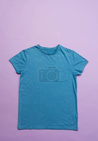 Foto de Camiseta azul y espacio de copia sobre fondo púrpura. Moda, ropa, color y concepto de tela. - Imagen libre de derechos