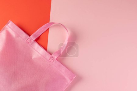 Téléchargez les photos : Sac en toile rose avec espace de copie sur fond rose et rouge. Shopping, sac, couleur, tissu, texture et matériaux concept. - en image libre de droit
