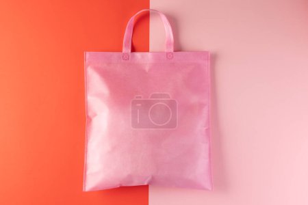 Foto de Bolsa de lona rosa con espacio para copiar sobre fondo rosa y rojo. Compras, bolsa, color, tela, textura y concepto de materiales. - Imagen libre de derechos