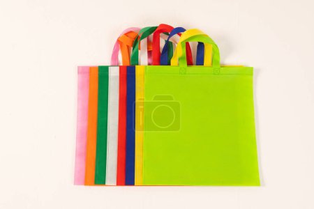 Foto de Fila de bolsas de lona multicolor con espacio de copia sobre fondo blanco. Compras, bolsa, color, tela, textura y concepto de materiales. - Imagen libre de derechos