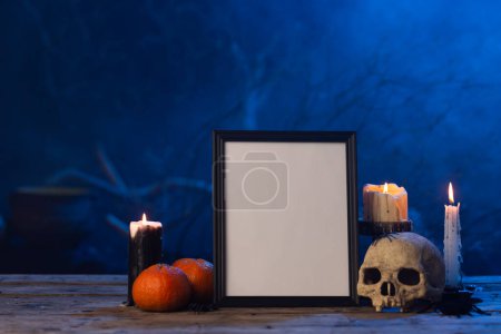 Foto de Marco negro con espacio de copia, cráneo, velas y humo sobre fondo azul. Halloween, color, movimiento y concepto de humo. - Imagen libre de derechos