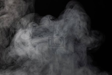 Foto de Nubes blancas de humo con espacio de copia sobre fondo negro. Halloween, color, movimiento y concepto de humo. - Imagen libre de derechos