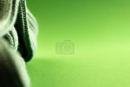 Foto de Micro primer plano de tejido de ganchillo de lana verde con espacio de copia sobre fondo verde. Micro fotografía, tela, patrón, textura y concepto de color. - Imagen libre de derechos