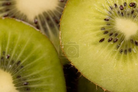 Photo for Micro close up of sliced kiwi fruit and copy space on black background. Micro photography, food, texture and colour concept. - Royalty Free Image