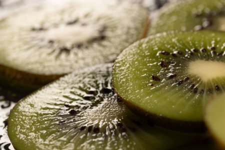 Photo for Micro close up of sliced kiwi fruits with water drops and copy space on black background. Micro photography, food, texture and colour concept. - Royalty Free Image
