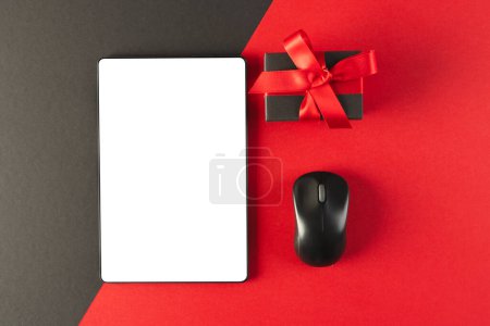 Photo for Tablet with blank screen, mouse and gift with copy space on red and black background. Cyber monday, cyber shopping, retail, technology, electronic device and communication concept. - Royalty Free Image