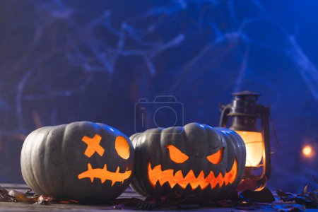 Photo for Carved pumpkins and lantern with copy space on blue background. Fall, autumn, halloween, tradition and celebration concept. - Royalty Free Image