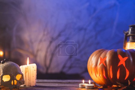 Photo for Carved pumpkin, skull and candle with copy space on blue background. Fall, autumn, halloween, tradition and celebration concept. - Royalty Free Image
