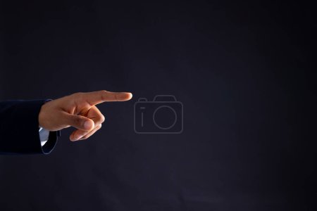 Photo for Hand of biracial businessman pointing with copy space on black background. Technology, digital networks, global connections and communication metaverse. - Royalty Free Image