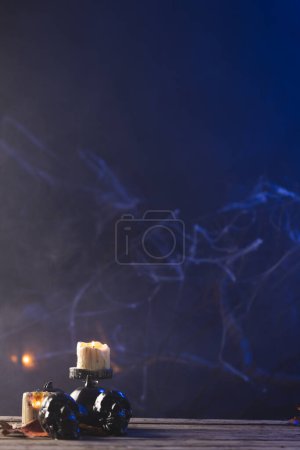 Photo for Vertical image of pumpkin, skulls and candles with copy space on dark background. Fall, autumn, halloween, tradition and celebration concept. - Royalty Free Image