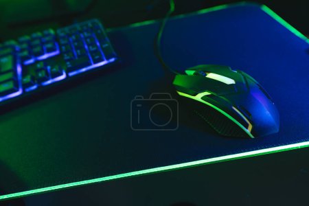 Photo for Composite of computer, keyboard with video game accessories with copy space on neon background. Video game and digital connections concept digitally generated image. - Royalty Free Image
