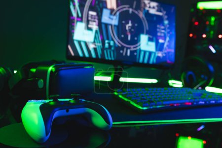 Photo for Composite of computer, keyboard with video game accessories with copy space on neon background. Video game and digital connections concept digitally generated image. - Royalty Free Image
