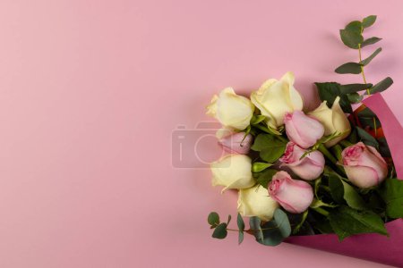 Photo for Bunch of pink and white roses in pink paper with copy space on pink background. Flower, plant, shape, nature and colour concept. - Royalty Free Image