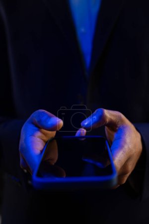 Photo for Vertical image of hands of biracial businessman with smartphone with copy space on black background. Technology, digital networks, global connections and communication metaverse. - Royalty Free Image