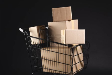Photo for Shopping trolley with boxes and copy space over black background. Cyber monday, black friday, online shopping, shipping and global connections concept. - Royalty Free Image