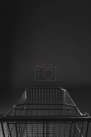 Photo for Vertical image of shopping trolley with copy space over black background. Cyber monday, black friday, online shopping, shipping and global connections concept. - Royalty Free Image