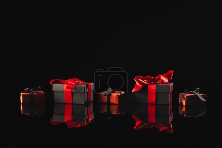 Photo for Black and red gift boxes with ribbon and copy space over black background. Cyber monday, black friday, online shopping, shipping and global connections concept. - Royalty Free Image