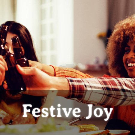 Photo for Festive joy text for thanksgiving over diverse friends toasting with beers. Thanksgiving, harvest festival, american tradition, family and autumn celebration digitally generated image. - Royalty Free Image