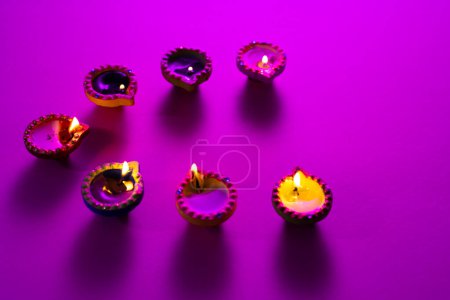 Téléchargez les photos : Gros plan de sept bougies diwali avec espace de copie sur fond violet. Diwali, fête des lumières, religion, tradition hindoue et célébration. - en image libre de droit