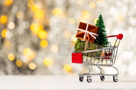 Téléchargez les photos : Chariot à sauter avec cadeaux et lumières de fées de Noël avec fond d'espace de copie. Noël, décorations, concept de tradition et de célébration. - en image libre de droit