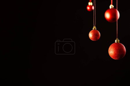 Téléchargez les photos : Boules de Noël rouges avec espace de copie sur fond noir. Noël, décorations, concept de tradition et de célébration. - en image libre de droit