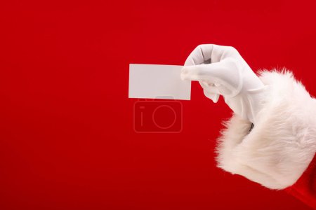 Photo for Santa claus holding white card with copy space on red background. Santa claus, christmas, tradition and celebration concept. - Royalty Free Image