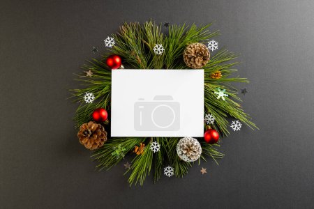 Foto de Decoraciones navideñas con tarjeta blanca y espacio para copiar sobre fondo negro. Navidad, decoraciones, tradición y concepto de celebración. - Imagen libre de derechos