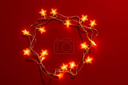 Foto de Luces de hadas de Navidad y espacio de copia sobre fondo rojo. Navidad, decoraciones, tradición y concepto de celebración. - Imagen libre de derechos