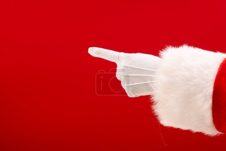Photo for Santa claus pointing with finger with copy space on red background. Santa claus, christmas, tradition and celebration concept. - Royalty Free Image