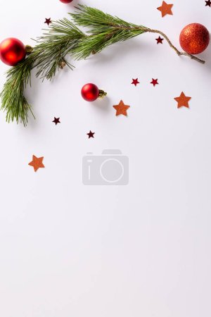 Photo for Vertical image of stars, baubles decorations and fir tree branch with copy space on white background. Christmas, decorations, tradition and celebration concept. - Royalty Free Image