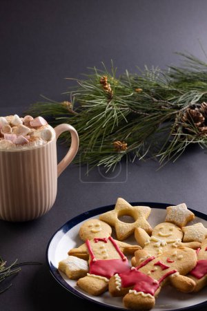 Téléchargez les photos : Image verticale de tasse chocolat avec guimauves, biscuits de Noël, espace de copie sur fond noir. Bonbons, Noël, concept de tradition et de célébration. - en image libre de droit