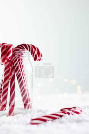 Foto de Imagen vertical de tarro de bastones de caramelo de Navidad con espacio de copia sobre fondo blanco. Postre, bebida dulce, navidad, tradición y concepto de celebración. - Imagen libre de derechos