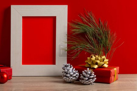 Foto de Decoraciones navideñas y marco de madera con espacio para copiar sobre fondo rojo. Navidad, decoraciones, tradición y concepto de celebración. - Imagen libre de derechos