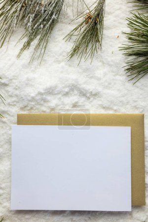 Foto de Imagen vertical de decoraciones navideñas y tarjeta blanca con espacio de copia sobre fondo de nieve. Navidad, decoraciones, tradición y concepto de celebración. - Imagen libre de derechos
